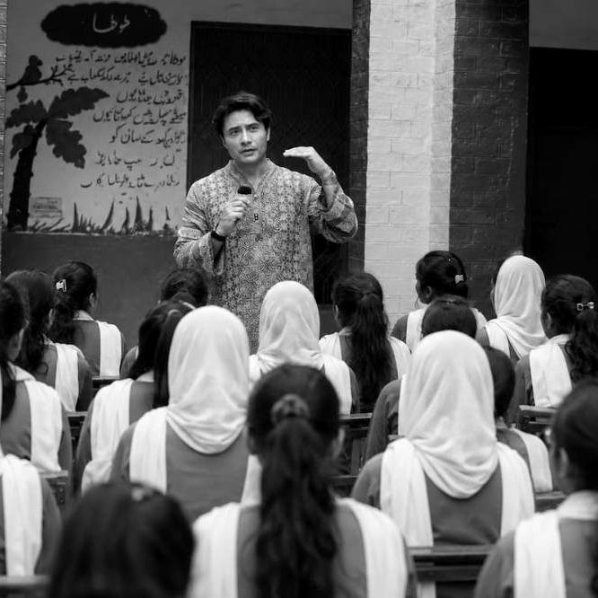 Ali Zafar speaking to a classroom